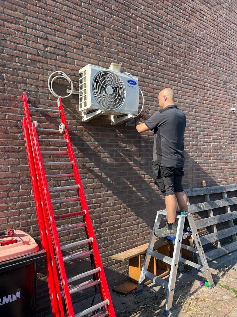 Monteur van Uw Loodgieter Service aan het werk bij een airco-installatie